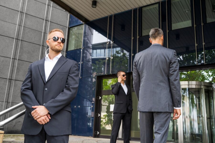 Two armed guards provide executive protection while traveling.