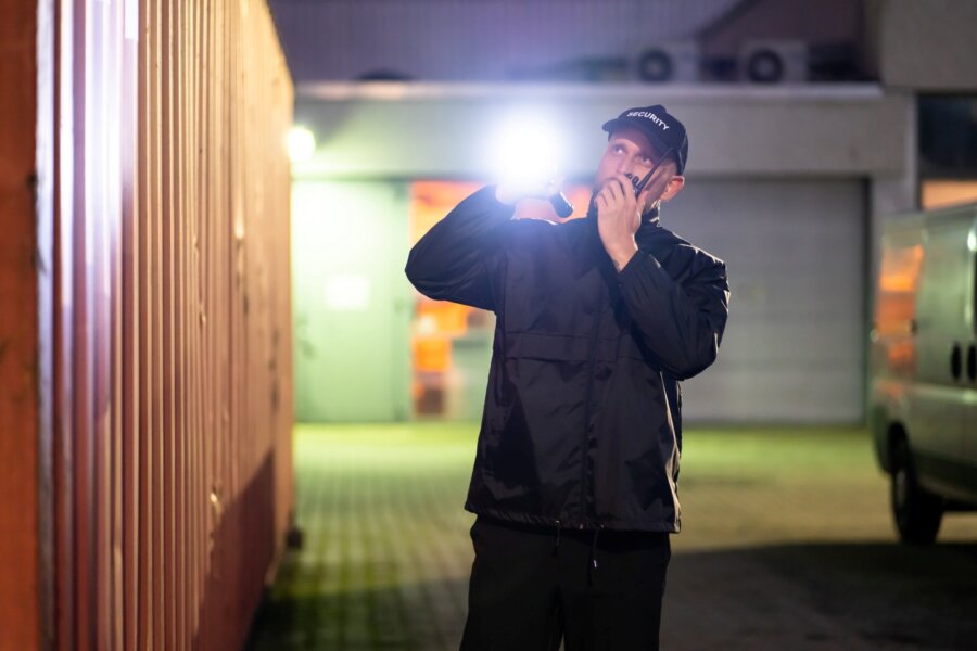 An unarmed security guard inspects the premises of a construction site.